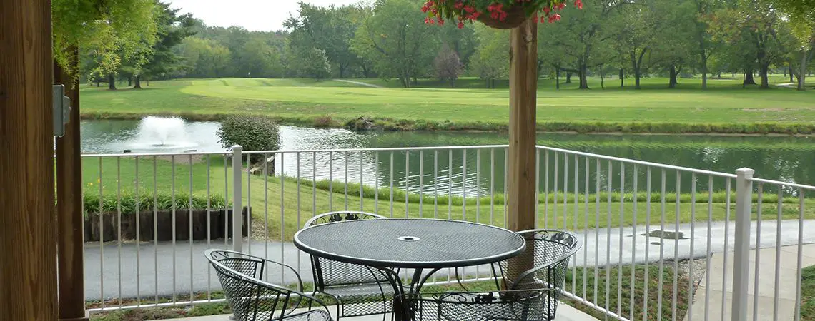 A table and chairs on the patio of an outdoor restaurant.