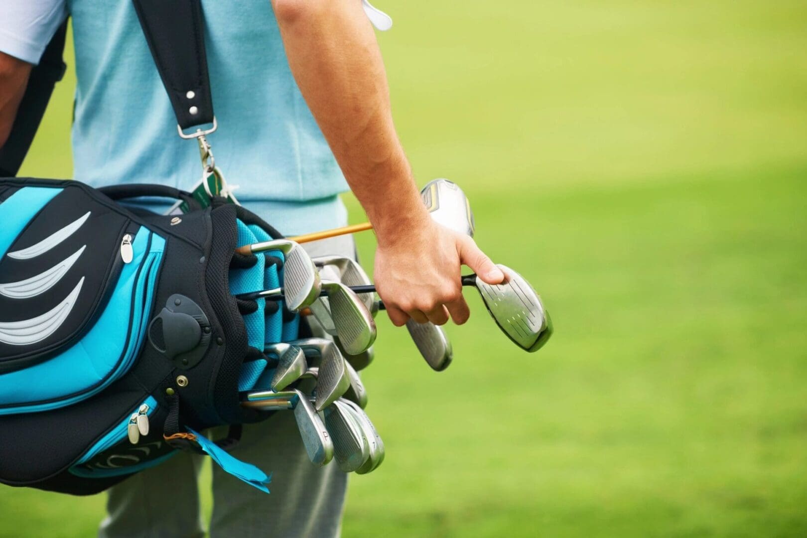 A person holding golf clubs in their hand.