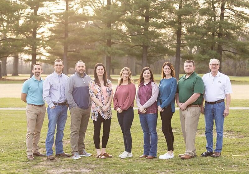 A group of people standing in the grass.